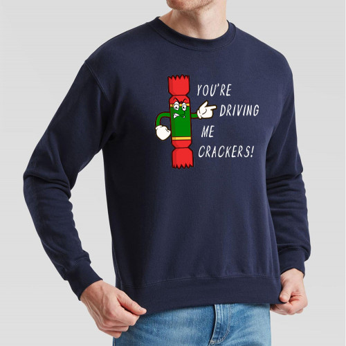 Navy Blue Jumper printed with text You’re Driving Me Crackers and a cartoon anthropomorphised Christmas cracker pointing to the wearer’s left.