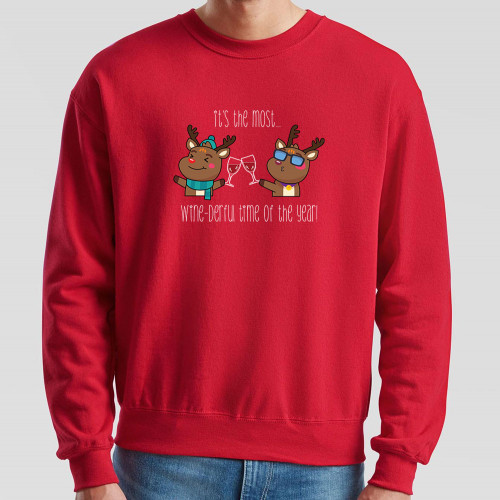 Red Jumper printed with cheerful design of reindeer enjoying a tipple and the text It’s The Most Wine-derful Time of The Year across the chest.